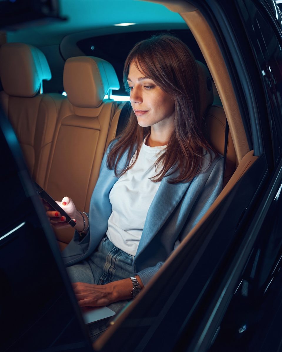 A guest working calmly in the back seat during an evening VOGA journey